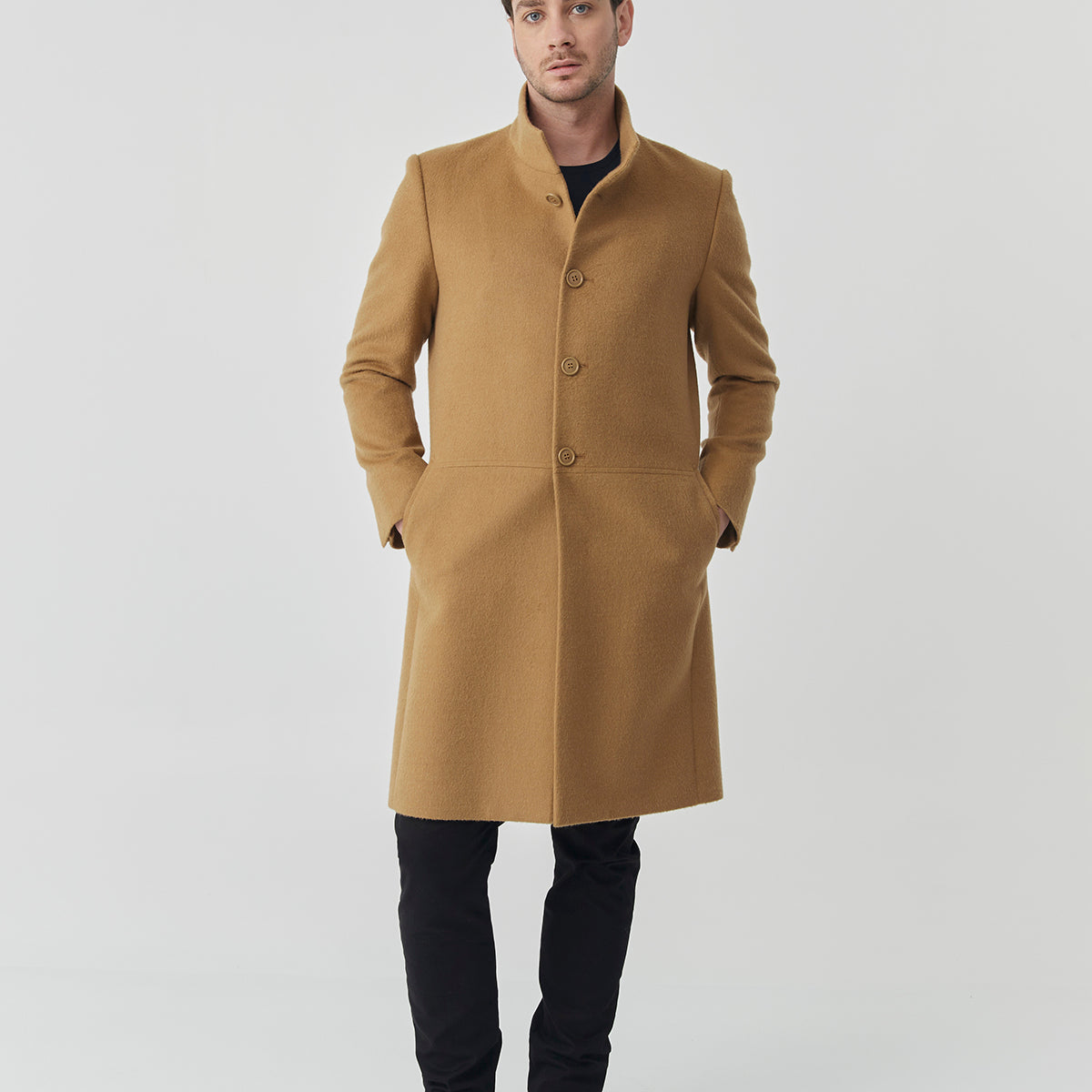 Man wearing a Baby Alpaca camel coat with front buttons and a high collar.