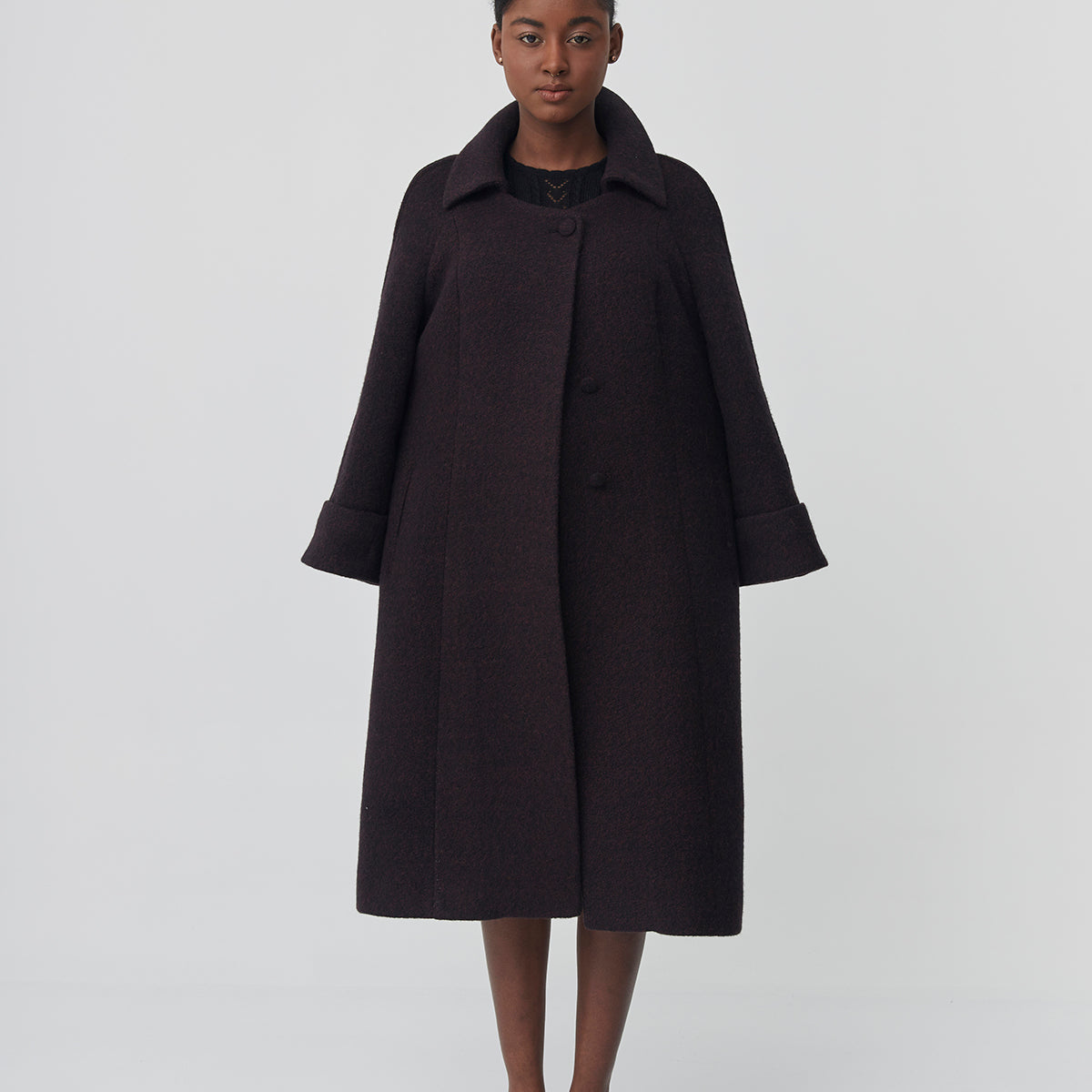 Person wearing a black coat on a white background