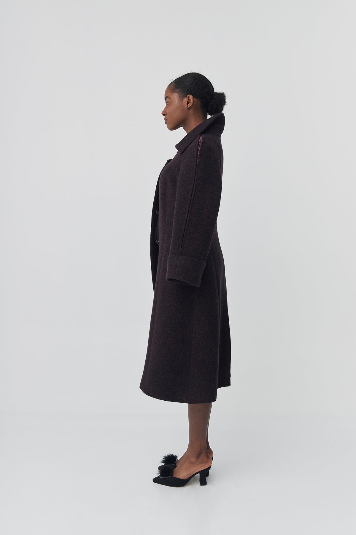 Person wearing a dark coat on a white background
