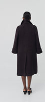 Person wearing a black coat on a white background
