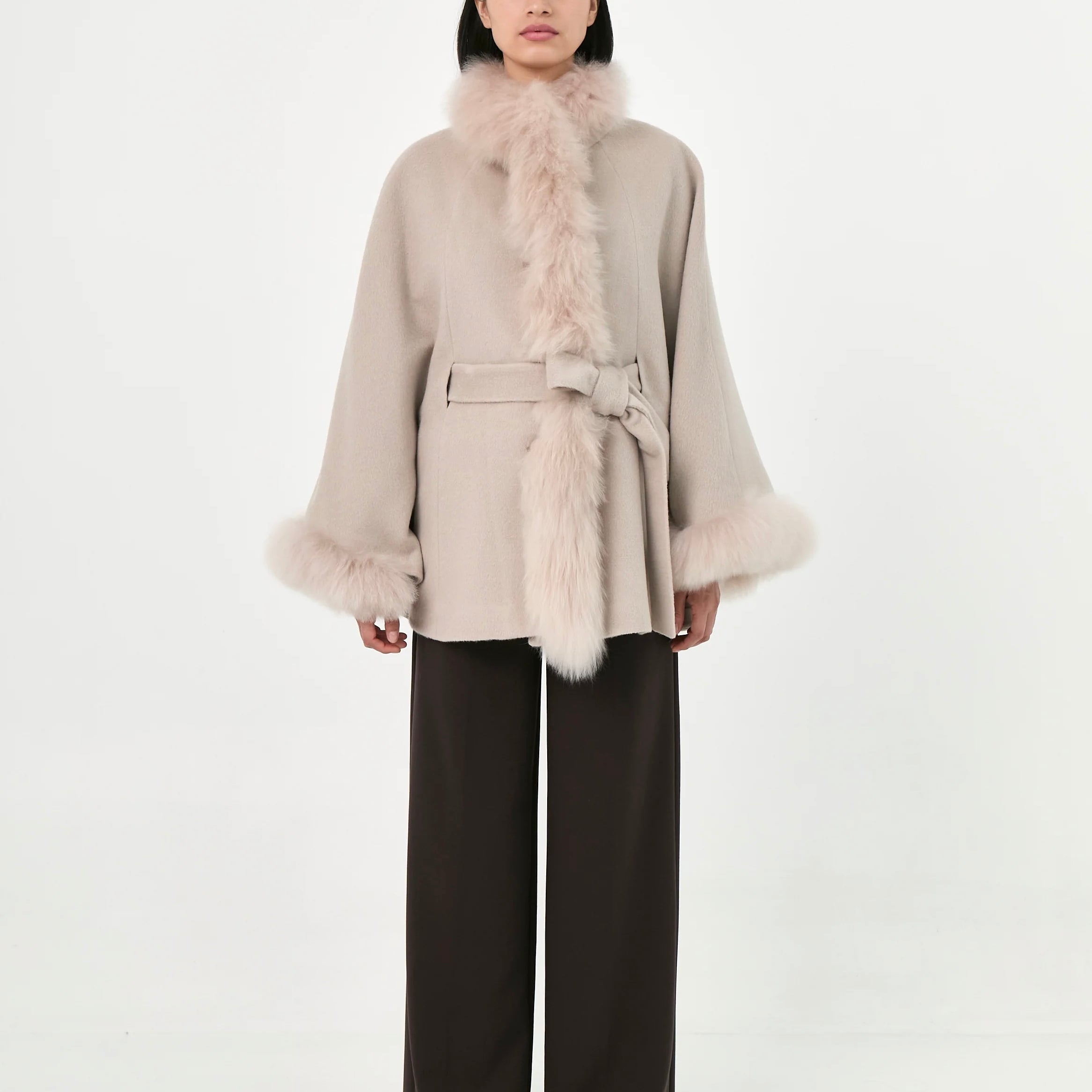 A model wearing a light beige Baby Alpaca belted Cape with fur.