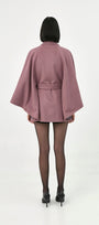A model viewed from the back wearing a rose mauve baby alpaca belted cape.